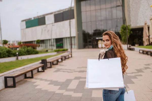 Egy Gyönyörű Fehér Maszkban Kesztyűben Áll Egy Bevásárlóközpont Előtt Táskákkal — Stock Fotó