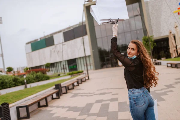 Egy Gyönyörű Fehér Maszkban Kesztyűben Áll Egy Bevásárlóközpont Előtt Táskákkal — Stock Fotó