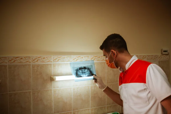Ein Junger Kaukasischer Zahnarzt Mit Maske Betrachtet Ein Röntgenbild Der — Stockfoto