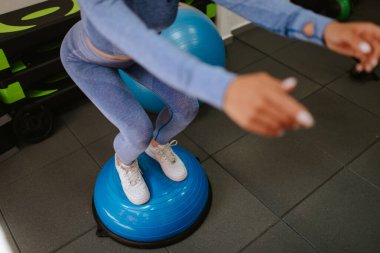 Genç, güzel, beyaz kadın spor salonunda mekik çekiyor. 