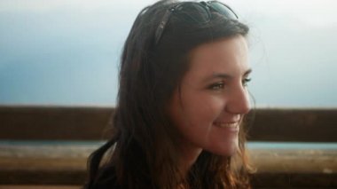 Güzel genç kadın gülümse ve kameraya yavaş yavaş bak.