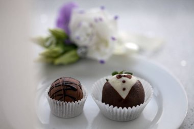 Düğün tatlısı. Çikolatalı şekerler beyaz bir tabakta..