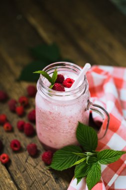 Payet rustik ahşap arka plan üzerinde bir mason kavanoza pembe ahududu güler yüzlü