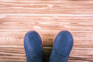 Şık çocuk kışlık botlar ahşap arka plan üzerinde