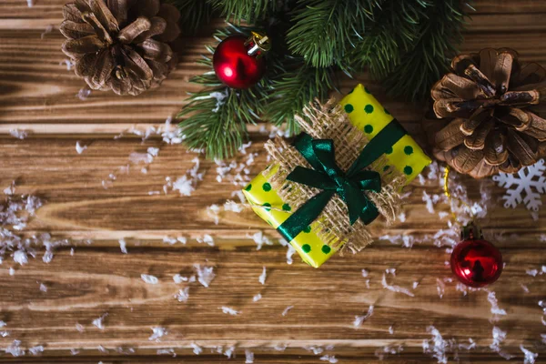 Scatola regalo di Natale con rami di abete su uno sfondo di legno — Foto Stock