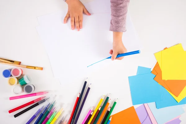 Маленькая девочка рисует цветными карандашами на бумаге — стоковое фото