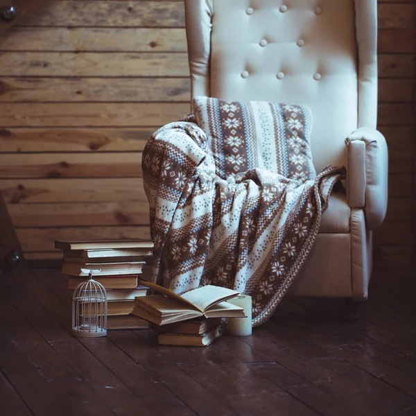 Куча книг с теплым пледом на стуле — стоковое фото