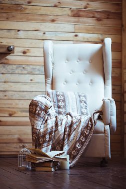 Sandalye üzerinde sıcak ekose ile kitap yığını