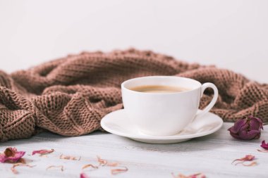 Kış kapuçino kompozisyon. Köpük ve örme eşarp, beyaz tahta arka plan ile Blue kahve Kupası Üstten Görünüm