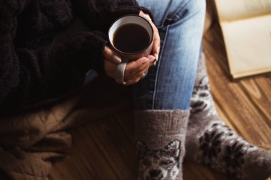 Gri bir fincan çay tutarak ve bir kitap okuma güzel manikür kadınla