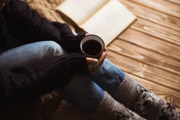 Gri bir fincan çay tutarak ve bir kitap okuma güzel manikür kadınla