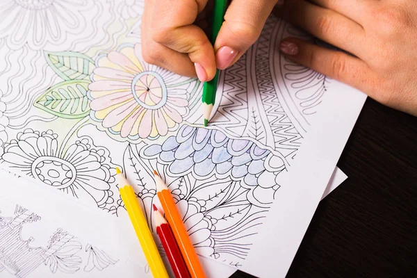 Chica pinta un libro para colorear para adultos con lápices de colores —  Fotos de Stock