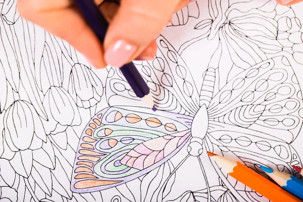 Fille peint un livre de coloriage pour adultes avec des crayons — Photo