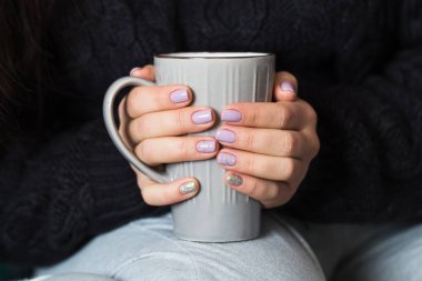 Güzel manikür gri bir fincan çay tutan kadınla