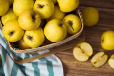 Ahşap arka plan üzerinde bir sepet içinde altın elma