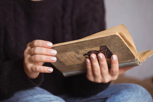 Kobieta z piękny manicure trzyma starej książki — Zdjęcie stockowe