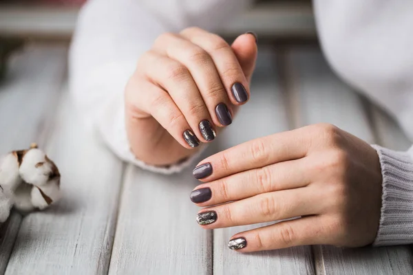 Handen met mooie manicure holding katoen bloem — Stockfoto