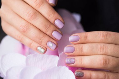 El bir pembe çiçekler üzerinde manikürlü tırnaklar