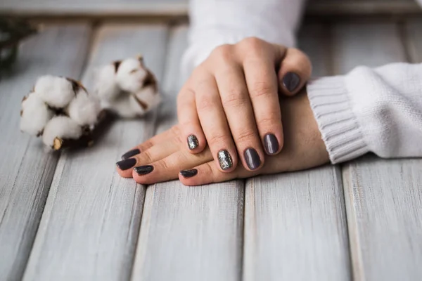 Handen met mooie manicure holding katoen bloem — Stockfoto