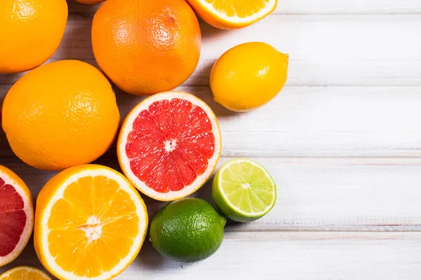 Verse citrusvruchten op een bruin houten tafel — Stockfoto