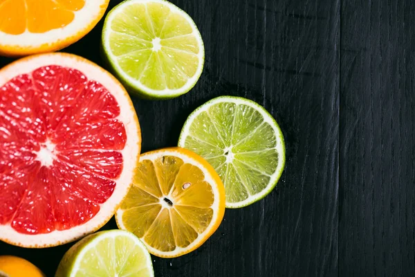 Cítricos frescos stihli. Limones, limas, pomelo y naranja sobre fondo negro —  Fotos de Stock