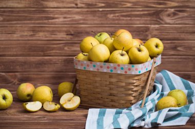 Ahşap arka plan üzerinde bir sepet içinde altın elma