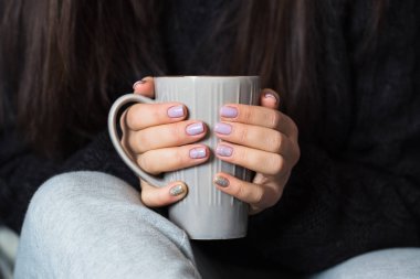 Güzel manikür gri bir fincan çay tutan kadınla