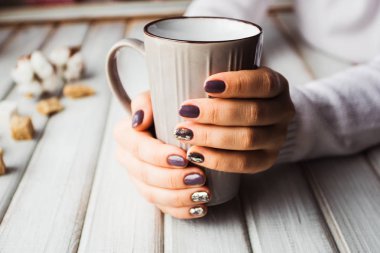 Güzel manikür gri bir fincan çay tutan kadınla