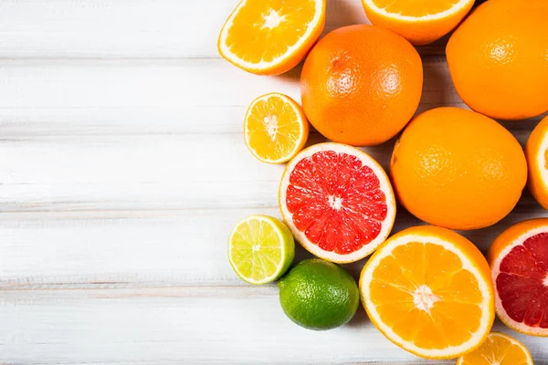 Verse citrusvruchten op een bruin houten tafel — Stockfoto