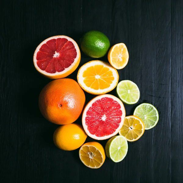 Cítricos frescos stihli. Limones, limas, pomelo y naranja sobre fondo negro — Foto de Stock