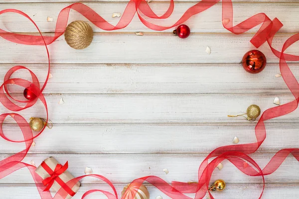 Scatola regalo di Natale con fiocco a nastro e palla giocattolo su sfondo di legno bianco — Foto Stock