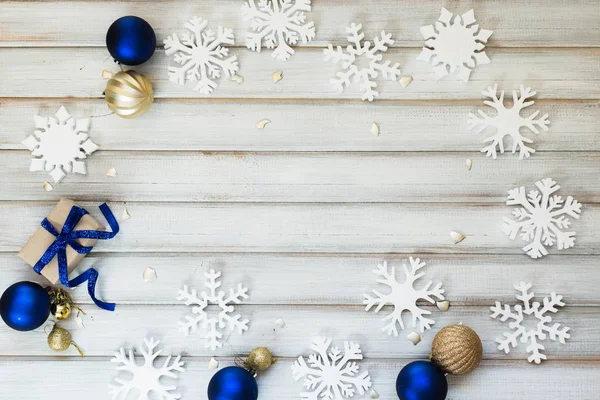 Scatola regalo di Natale con fiocco a nastro e palla giocattolo su sfondo di legno bianco — Foto Stock