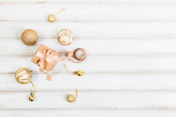 Scatola regalo di Natale con fiocco a nastro e palla giocattolo su sfondo di legno bianco — Foto Stock