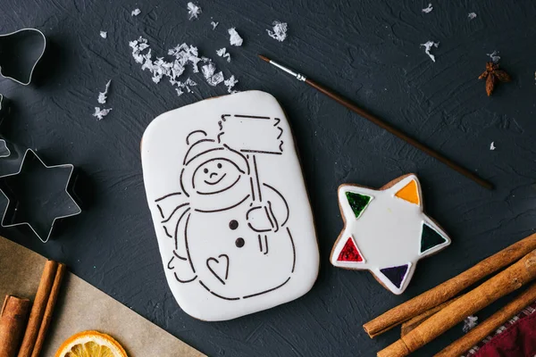 Galleta de jengibre de Navidad con glaseado y un muñeco de nieve pintado para ser pintado vista superior . —  Fotos de Stock