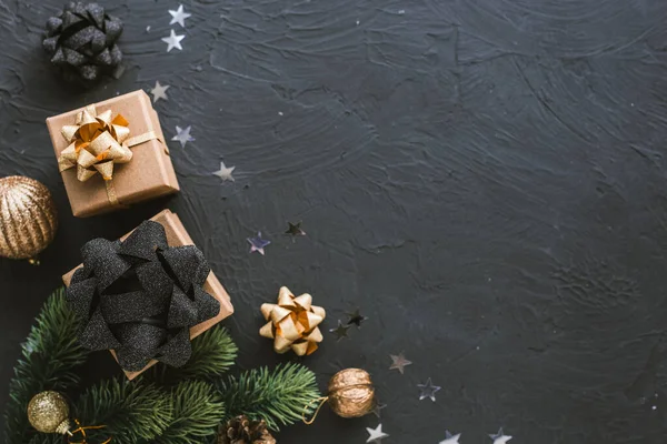 Christmas presents on a black background. Christmas background with fir tree, garlands, gifts. — ストック写真