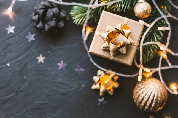 Christmas presents on a black background. Christmas background with fir tree, garlands, gifts. — ストック写真