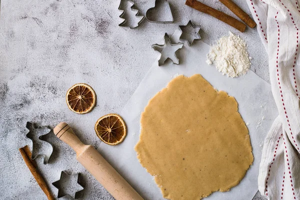 Приготовление рождественских пряников печенье на сером фоне — стоковое фото