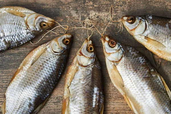 Peixes salgados na mesa de madeira — Fotografia de Stock