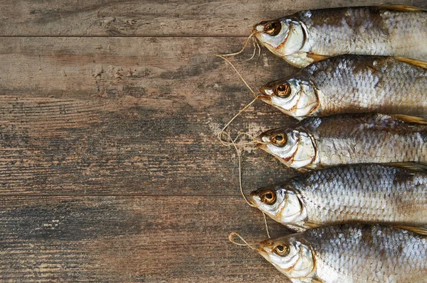 Peixes salgados na mesa de madeira — Fotografia de Stock