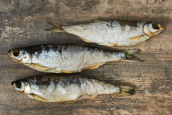 Peixes salgados na mesa de madeira — Fotografia de Stock