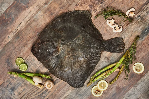 Pescado plano crudo sin cocer sobre mesa de madera Fotos De Stock Sin Royalties Gratis