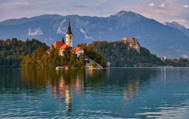Slovenya 'da küçük bir adadaki büyüleyici kilise. Arka planda muhteşem bir kale var..
