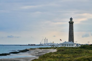 Resimli yazı, Skagen, Jutland, Danimarka, 08-29-2018. Skagen (Danimarka, Kuzey Jutland) yakınlarındaki Skagerrak (Kuzey Denizi) ve Kattegat (Baltık Denizi) kavşağında deniz feneri Grenen (Gri Kule olarak adlandırılır).)