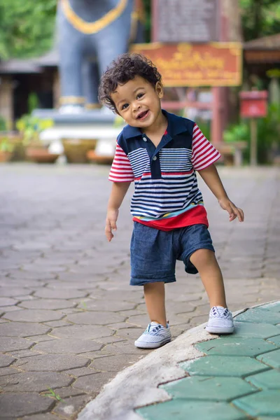 Asiatico bambino con ricci capelli cercando posa quando essere fotografato — Foto Stock