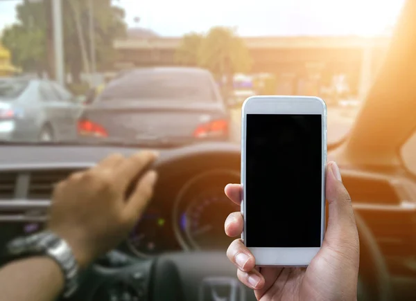 Med hjälp av en smartphone när du kör en bil — Stockfoto