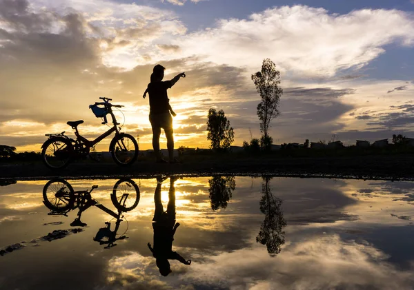 Reflection Silhouette of mother with her toddler against the sun — Stock Photo, Image