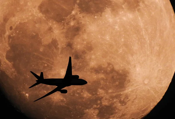 Silhouette airplane flying across the moon — Stock Photo, Image