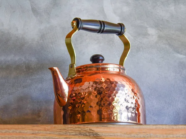 Old fashioned Copper Kettle on shelf.