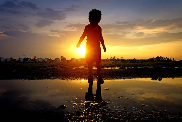 Silhouette asiatisches Kind und Reflexion Sonnenuntergang — Stockfoto