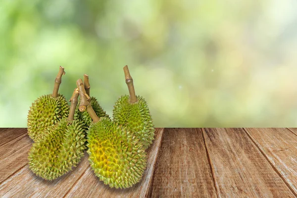 Grupo de durian sobre mesa de madeira e fundo de natureza verde . — Fotografia de Stock